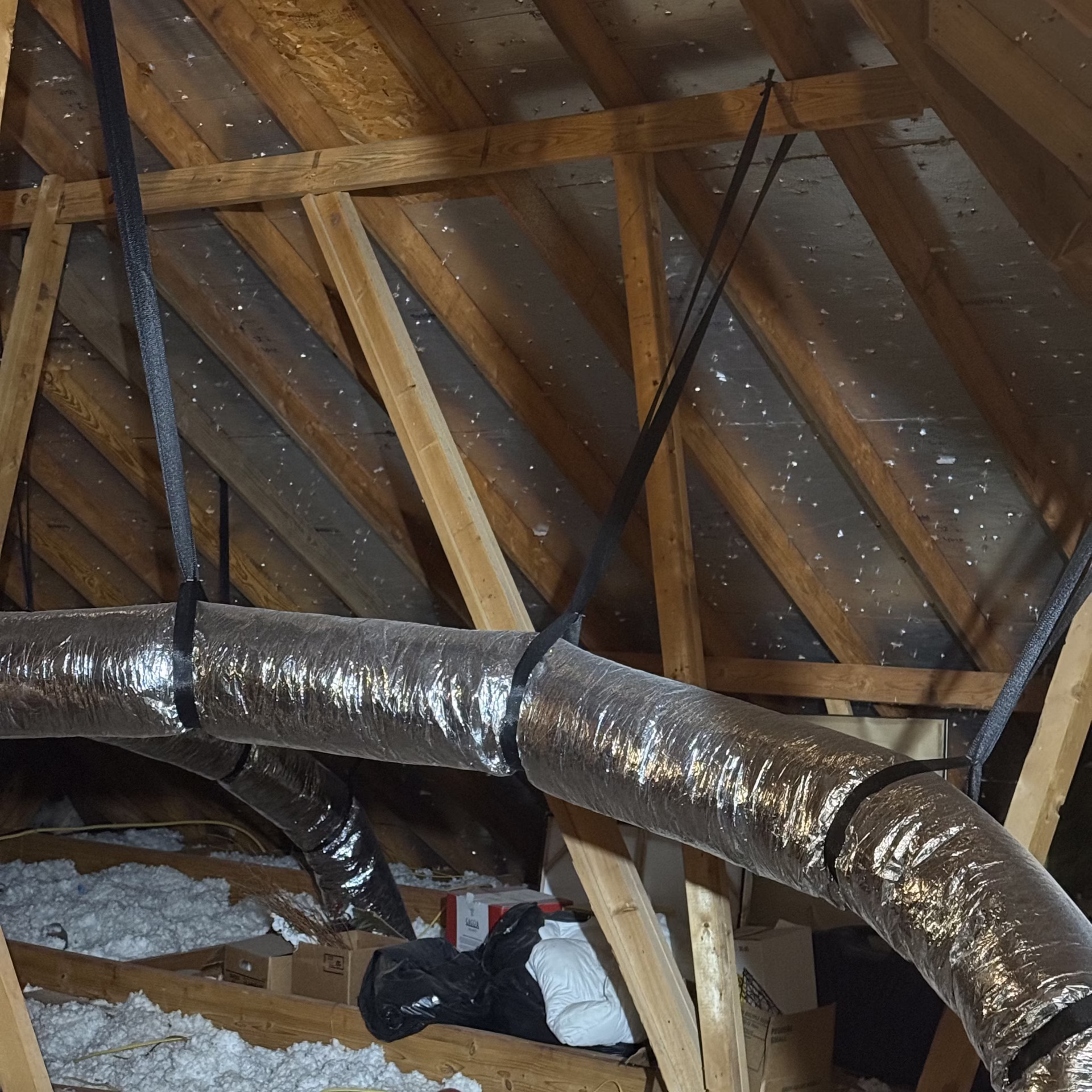 HVAC ductwork installed in an attic space demonstrating how duct leakage energy loss, insulation conditions, and airflow design affect air conditioning efficiency during hot Texas summers.