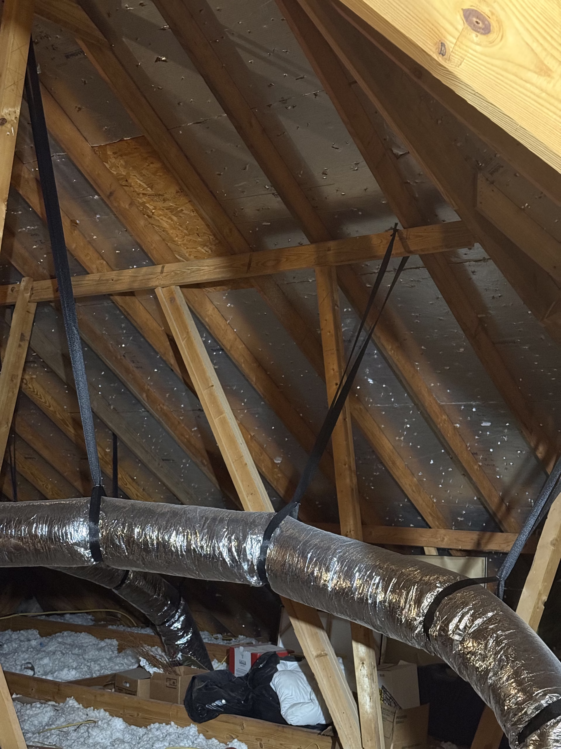 HVAC ductwork installed in an attic space demonstrating how duct leakage energy loss, insulation conditions, and airflow design affect air conditioning efficiency during hot Texas summers.