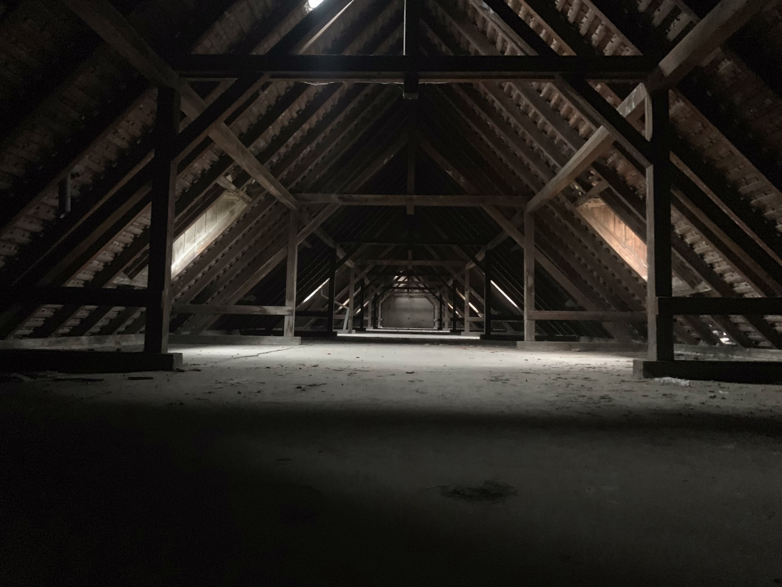 Unsealed attic with exposed framing and air gaps illustrating conditions before air sealing the attic and common causes of energy loss.