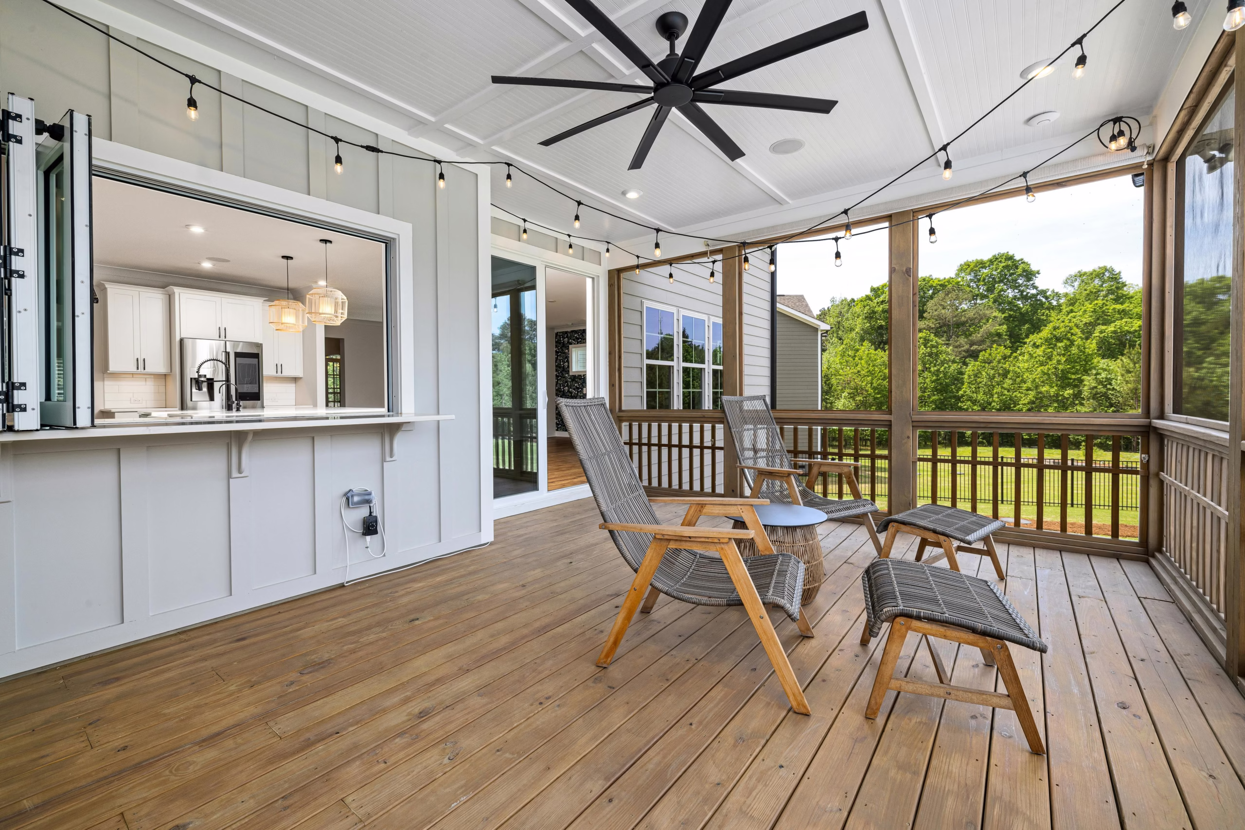 Screened in porch with open connection to the kitchen, wood decking, and ceiling fan, part of a screened in porch addition built by a general contractor Bryan homeowners rely on.