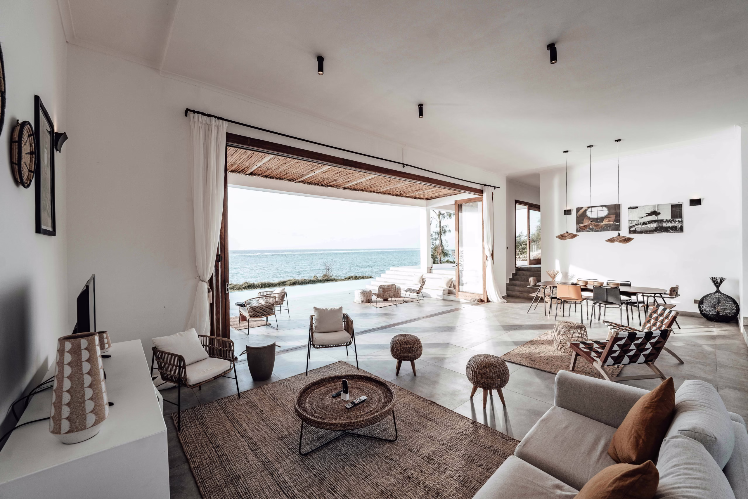 indoor outdoor home design flow with large opening connecting living space to exterior patio and natural surroundings