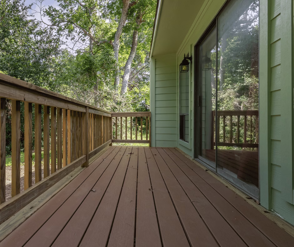 Attached side deck with wood planks and railing showing connection point to the home where deck construction mistakes often occur if not handled correctly by a deck builder