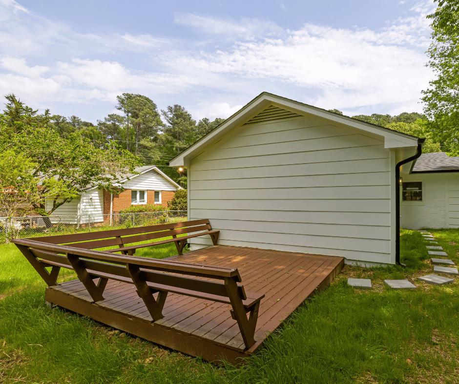 Ground-level wood deck with built-in bench seating showing simple framing layout, often used by a deck builder but vulnerable to deck construction mistakes when improperly connected to the home in Bryan College Station