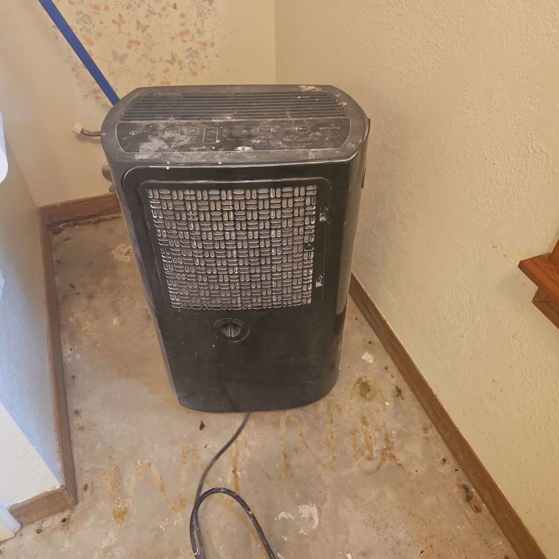 Portable air filtration unit positioned inside a residential remodeling work area to help manage airborne construction dust.