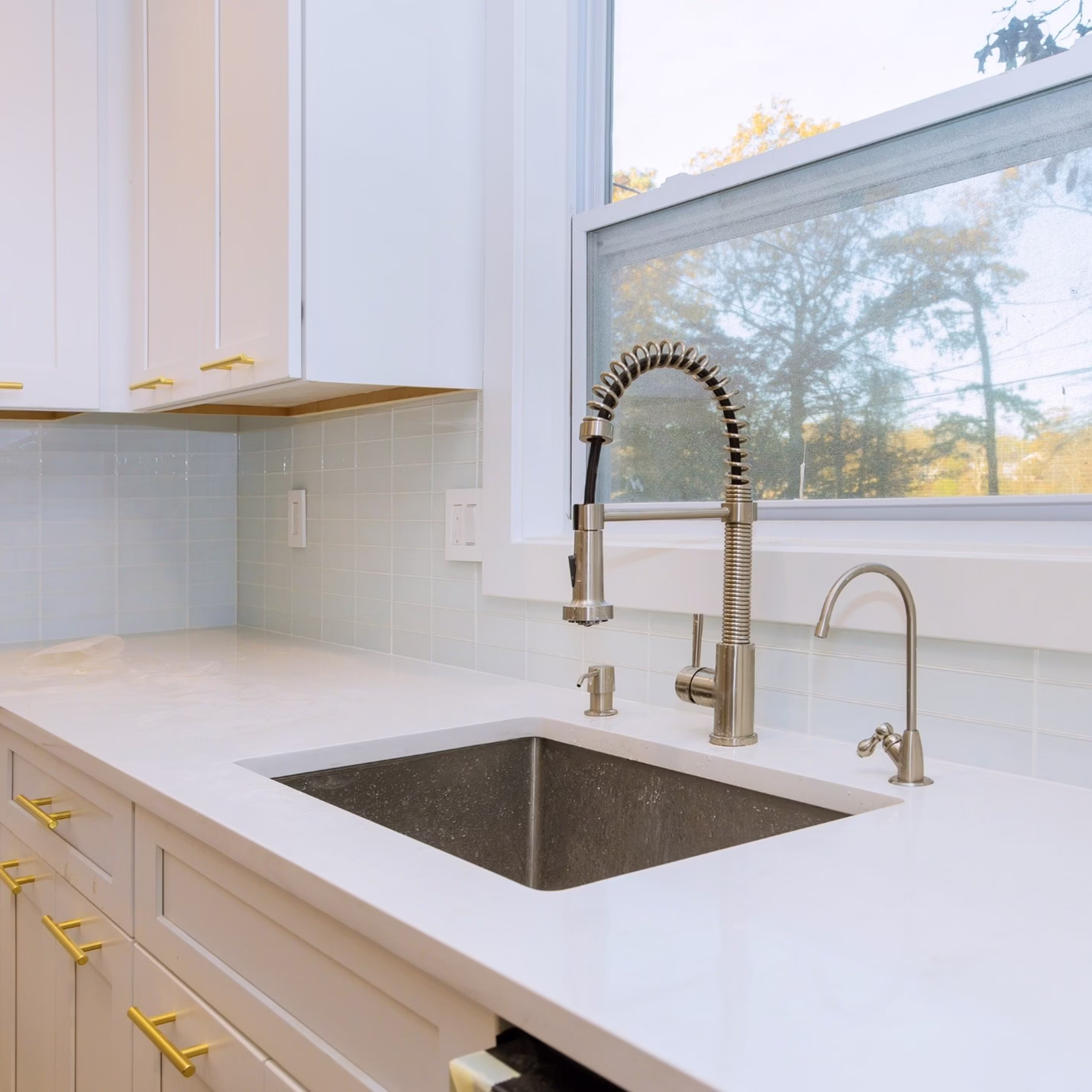 White kitchen with composite undermount sink and pull-down faucet showing practical kitchen sink materials and kitchen sink mounting styles for choosing a kitchen sink during a remodel