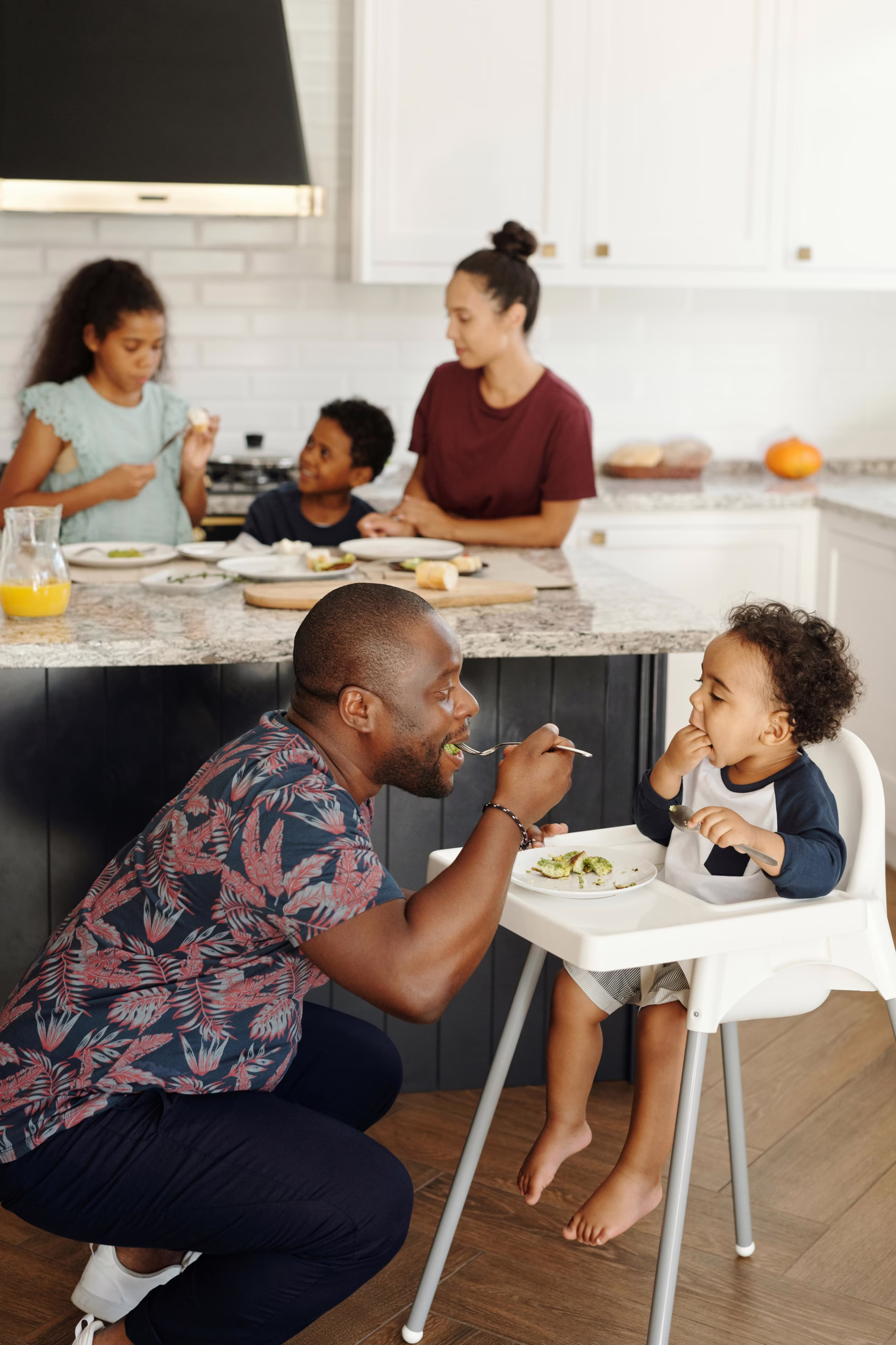 Family sharing breakfast in their kitchen, showing daily routines that influence whether homeowners should remodel or move.