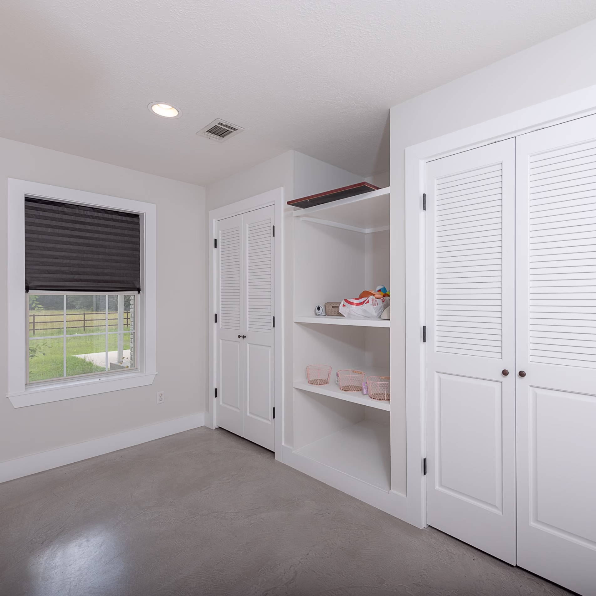 Built-in bedroom storage with open shelves and two closets incorporated into the wall.