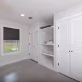 Built-in bedroom storage with open shelves and two closets incorporated into the wall.