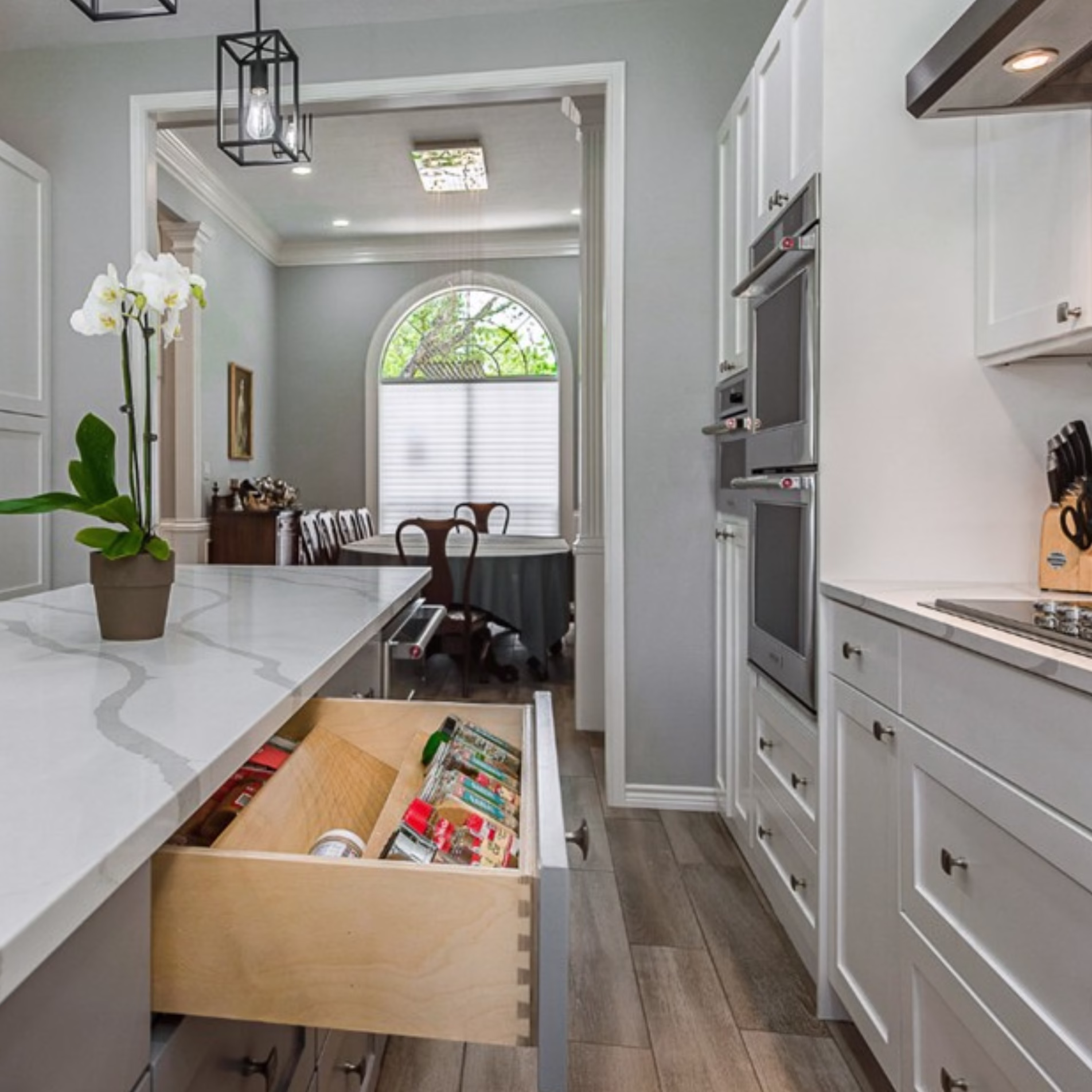 Deep kitchen island drawer with built-in dividers organizing spices and other cooking essentials.