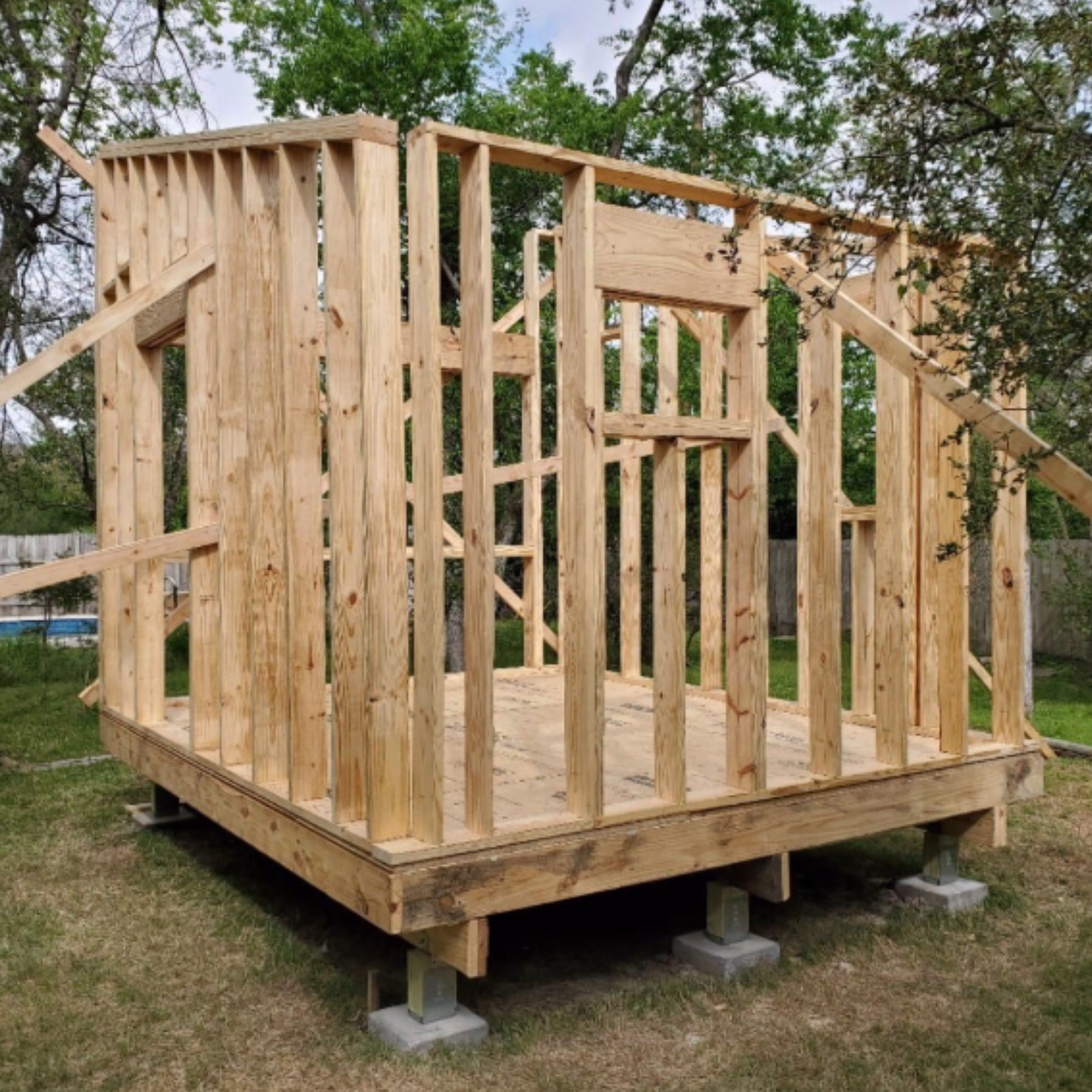 Wood framing under construction for a detached backyard home office addition.
