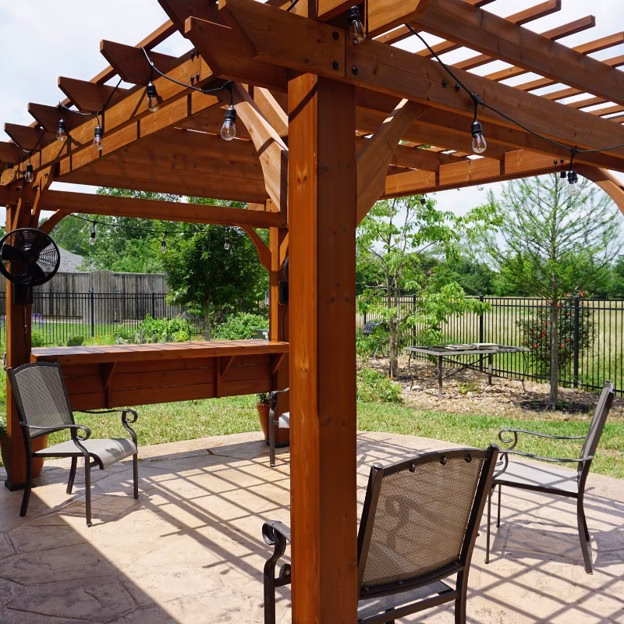 Front view of the completed outdoor living addition in College Station with cedar pergola, serving bar, and outdoor fans.