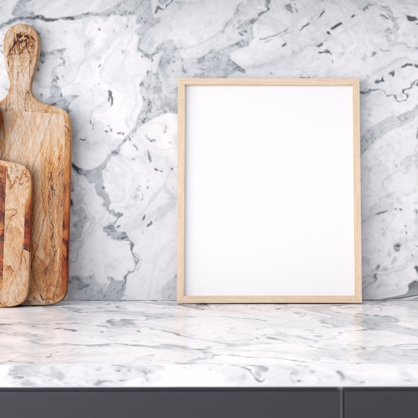 White porcelain countertop and backsplash with dramatic gray marble-look veining, decorative cutting boards, and a blank wood-framed display.