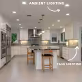 White kitchen with recessed ceiling lights providing ambient lighting and under-cabinet lights illuminating the countertops for task lighting.