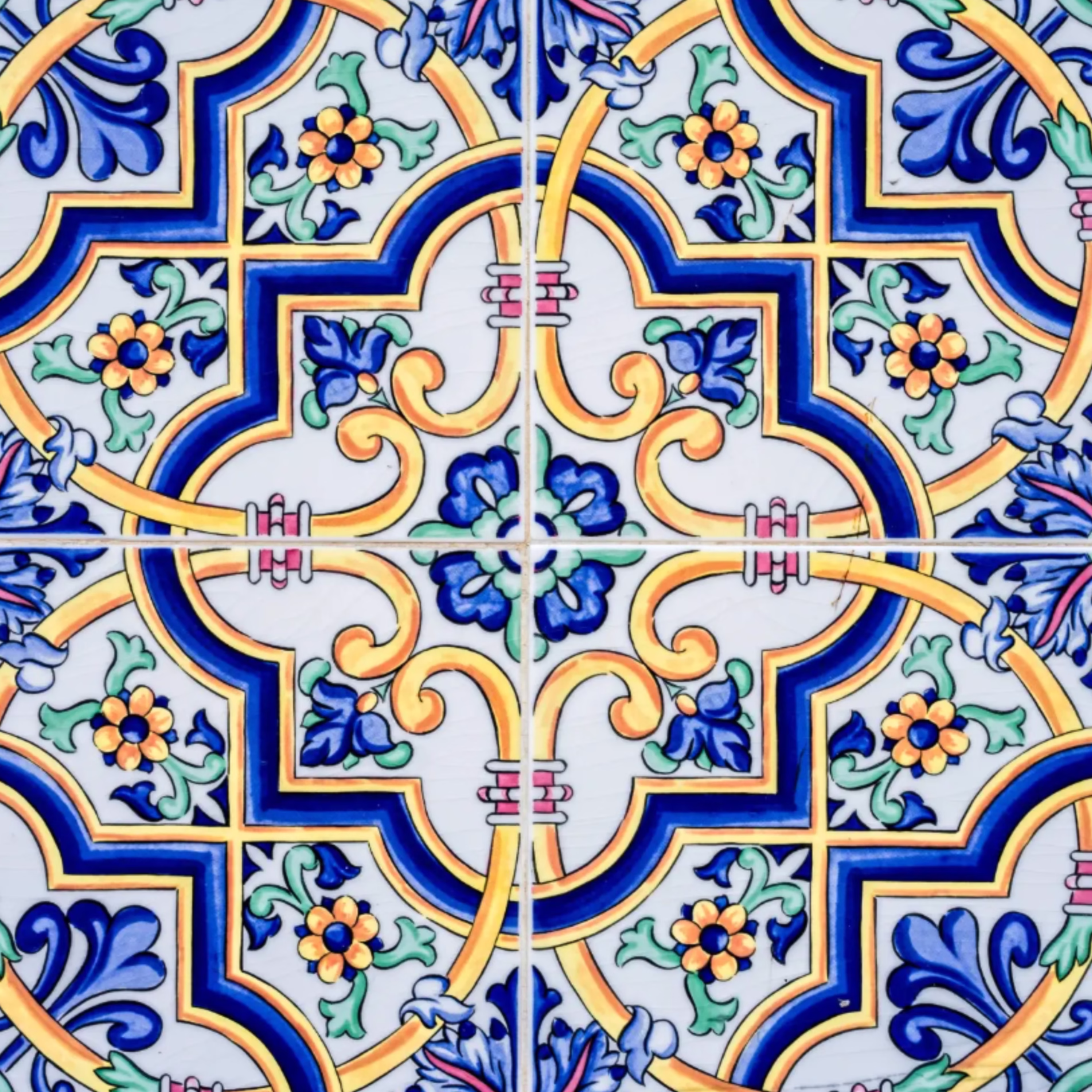 Colorful patterned tile with light grout separating the repeating decorative design.