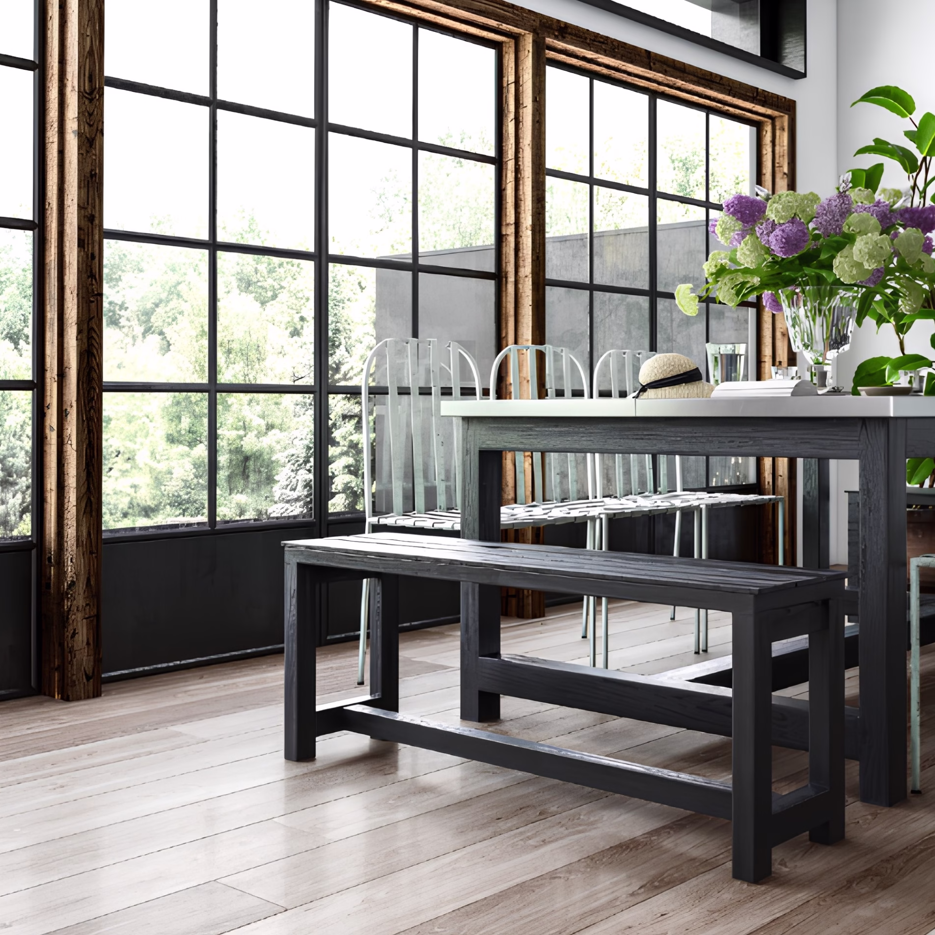 Dining area with large black-framed windows, wood trim, and a wooden table illuminated by natural daylight.