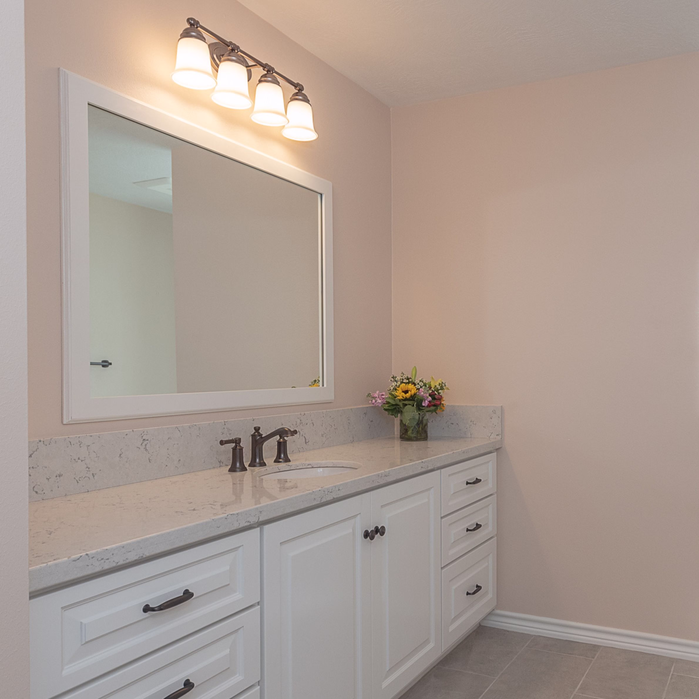 Bathroom vanity with light neutral paint and large mirror, demonstrating how to make a small bathroom feel bigger using reflective finishes and thoughtful small bathroom remodel ideas.