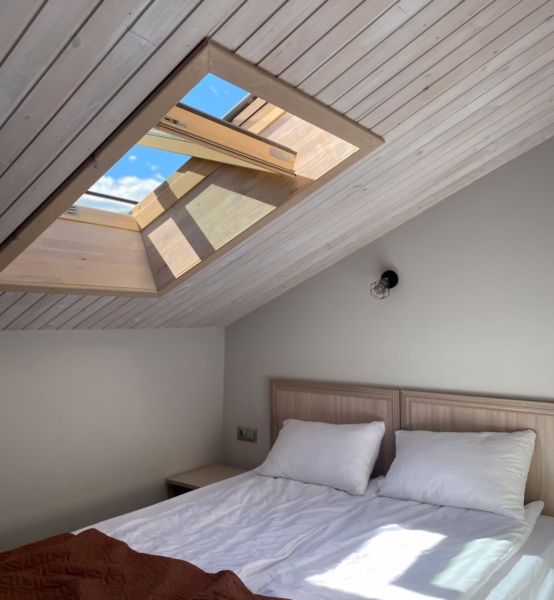 Bedroom with daylight filtering through sheer curtains, illustrating natural light and well-being at home in a restful sleeping space