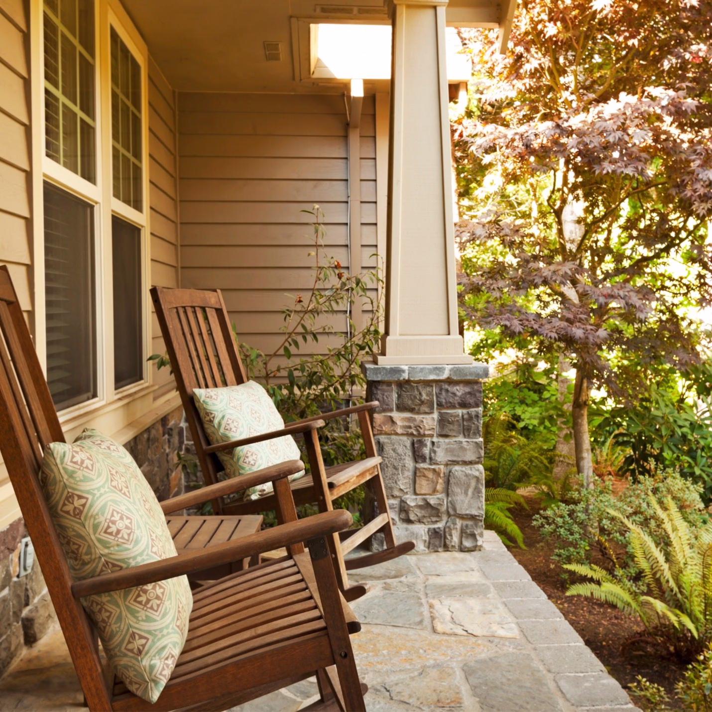 What transitions mean in home design shown by a front porch that creates a gradual shift between interior living space and the natural landscape outside