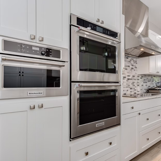 Built-in wall oven and microwave appliance layout in a white kitchen designed during kitchen remodel planning to support daily cooking routines
