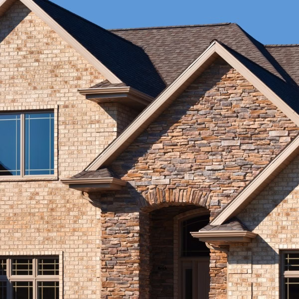 Brick and stone exterior used in moderation on a residential home, highlighting material placement considerations for brick homes in hot humid climates.