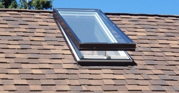 Roof-mounted skylight integrated into shingle roof assembly, showing one method of adding natural light to a house through controlled overhead glazing