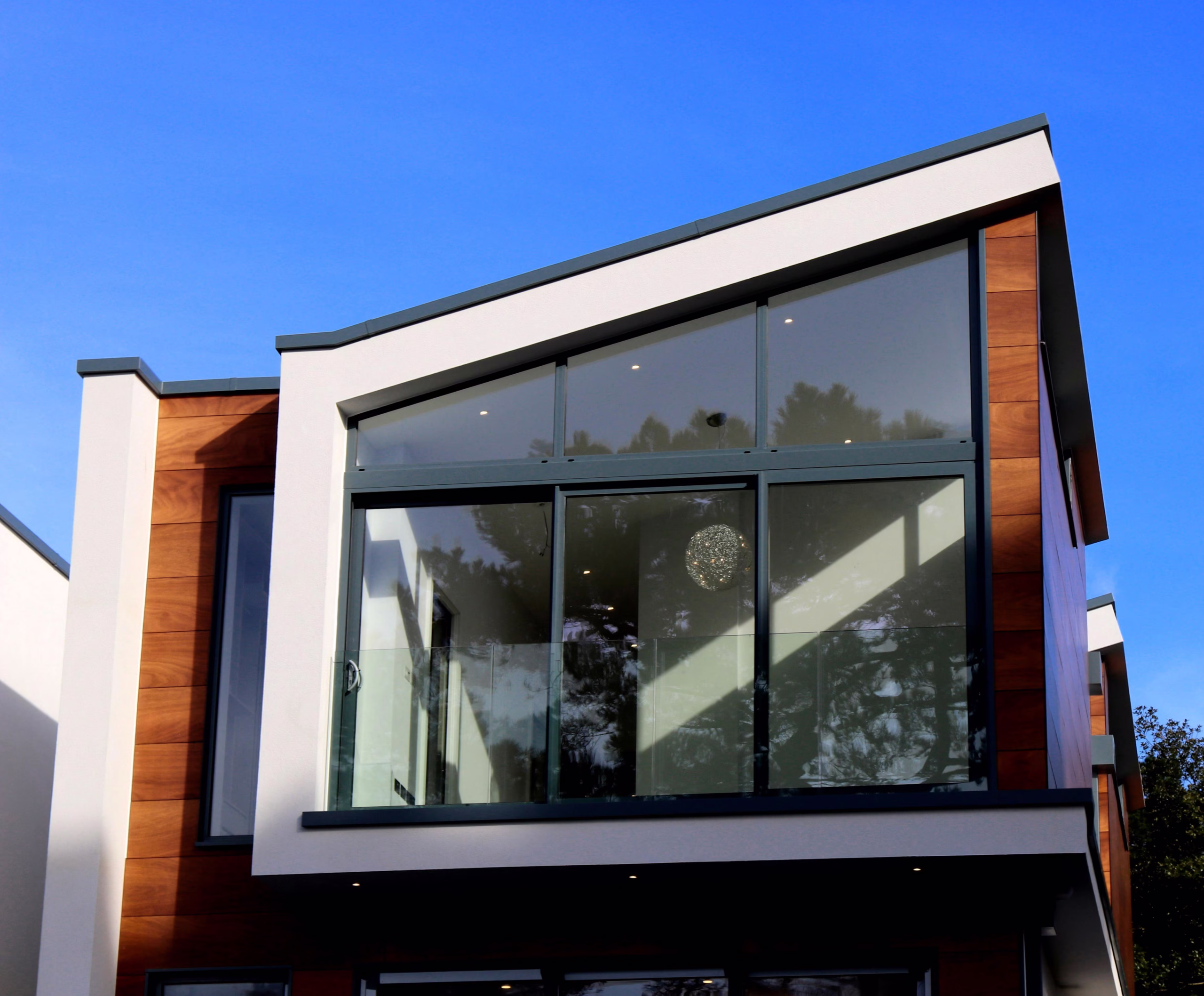 Modern home exterior featuring large energy efficient windows designed to reduce solar heat gain and improve comfort in hot climates.