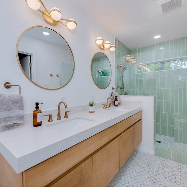 wide view of finished bathroom from historic home renovation College Station showing double vanity, green tile shower, and updated lighting layout