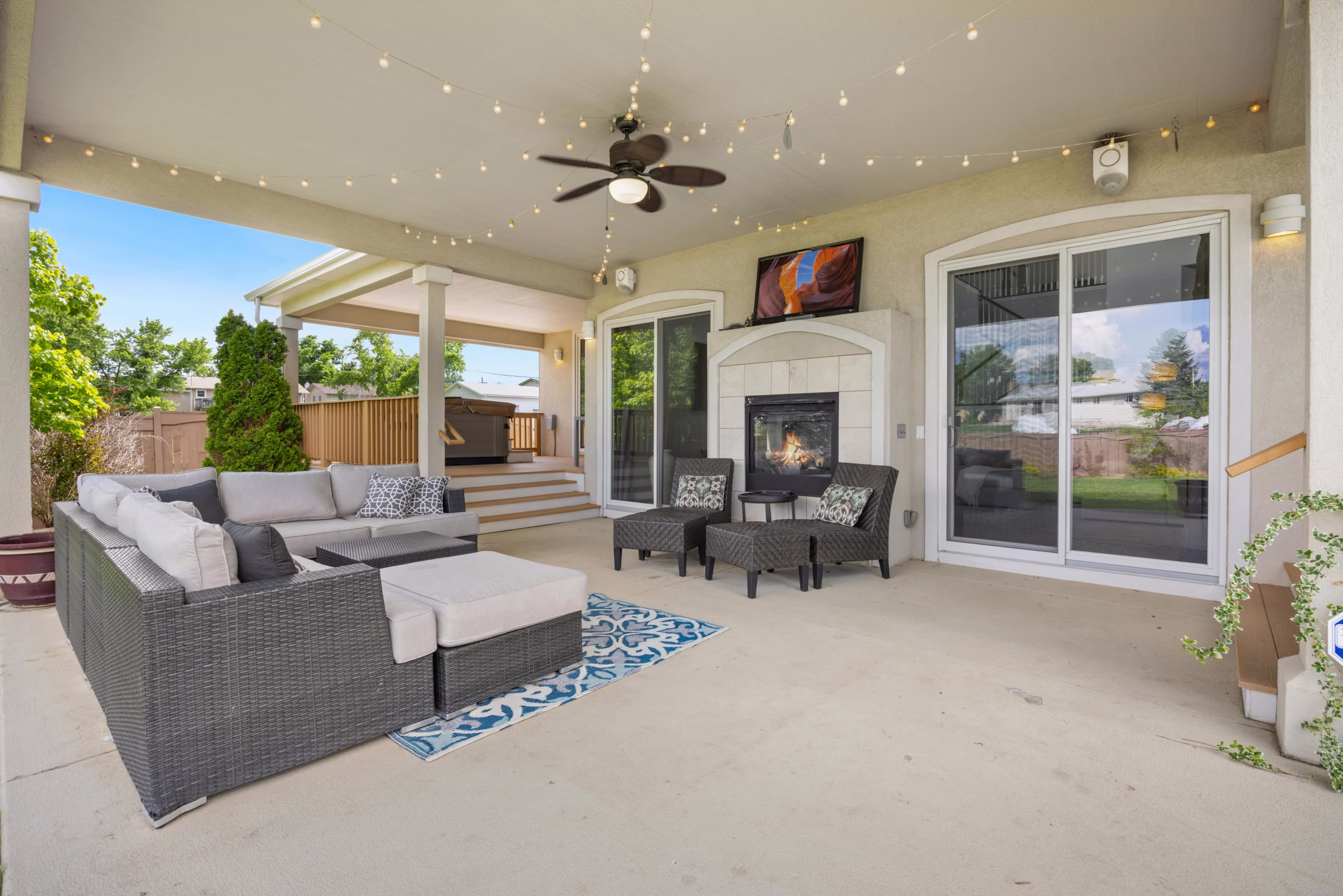 Covered outdoor living area with seating and fireplace demonstrating functional home design and home design for how you live through extended usable space