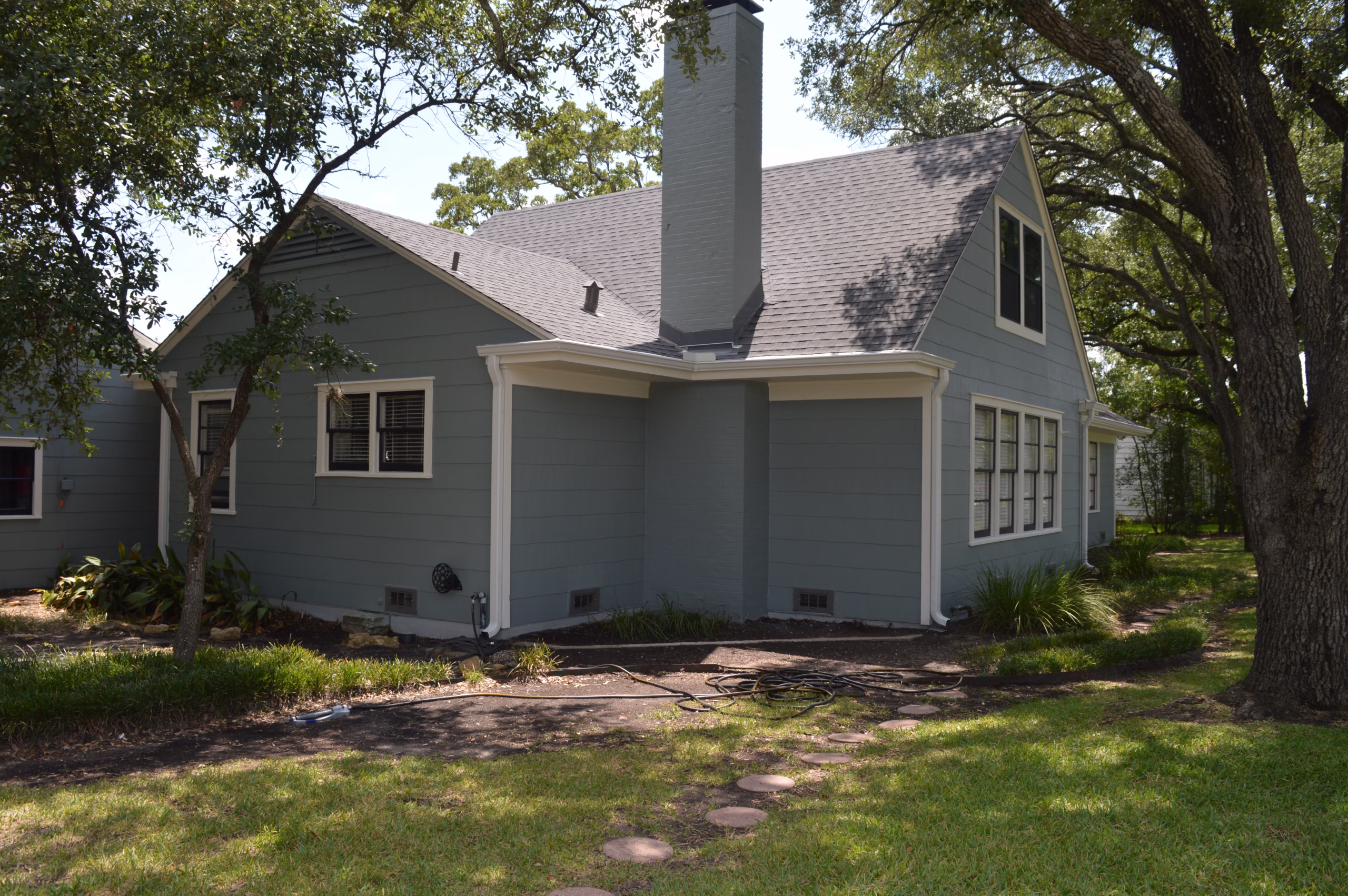 How to select exterior house paint colors using blue gray siding and white trim in a shaded natural setting