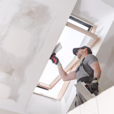 Contractor installing drywall near skylight during a home remodel showing proper construction practices by a design build firm in College Station