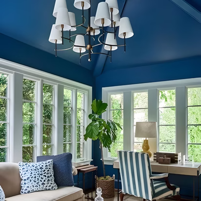 Deep blue living room with vaulted ceilings, white trim, and natural light demonstrating interior color planning and choosing colors for a remodel that creates energy and architectural depth in a home remodel Bryan TX project.