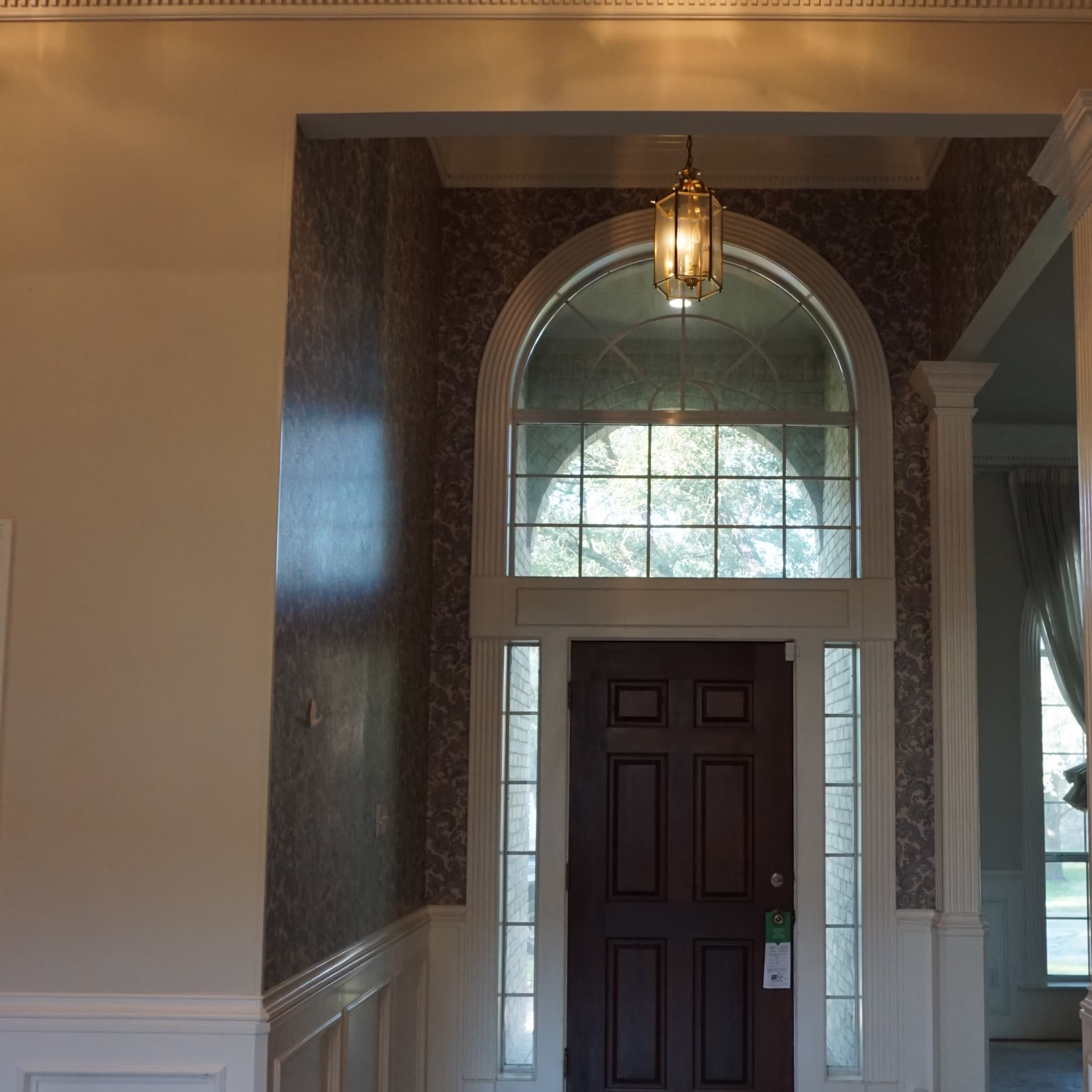 Entryway before remodeling with heavy decorative finishes and traditional architectural details prior to this whole home renovation designed for long-term living