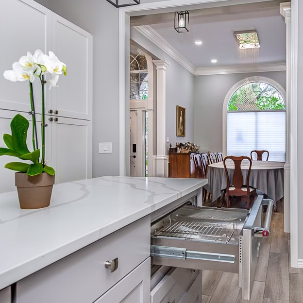 Custom kitchen organization features with pull-out storage and quartz countertops in this whole home remodel ideas project