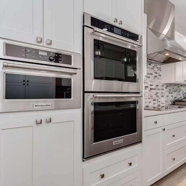 Custom kitchen appliance wall with built-in warming drawer and storage solutions during this whole home renovation College Station project