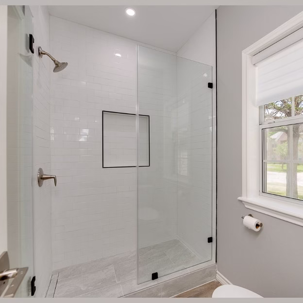 Secondary bathroom shower remodel with frameless glass, white subway tile, and updated finishes during this modern whole home renovation