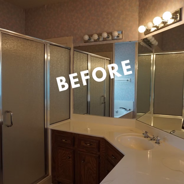Primary bathroom before the aging in place remodel with angled vanity layout, mirrored walls, and enclosed shower in this whole home remodel ideas project