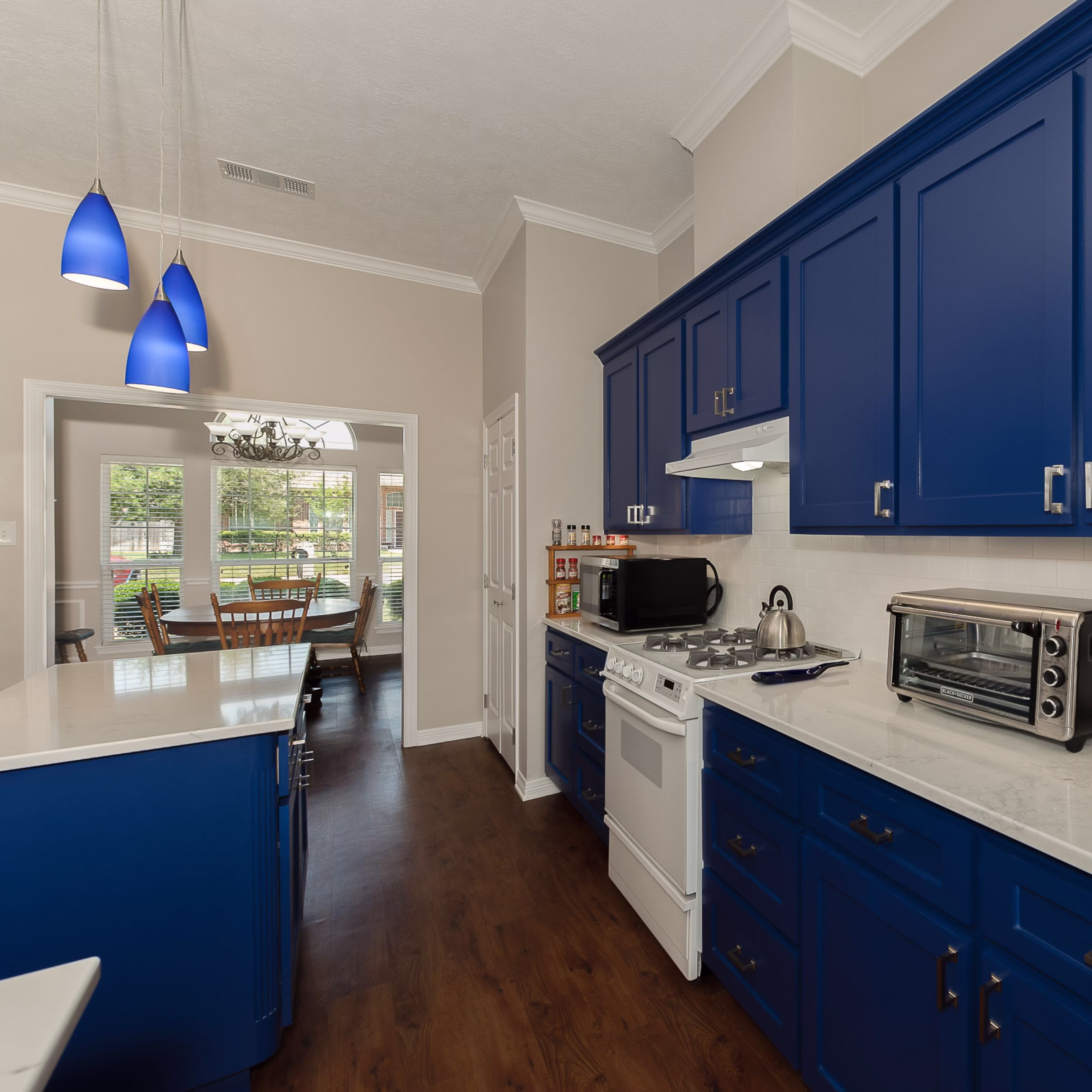Deep cobalt blue shaker cabinets and white quartz countertops showcasing this modern home remodel with improved storage, updated finishes, and enhanced functionality.