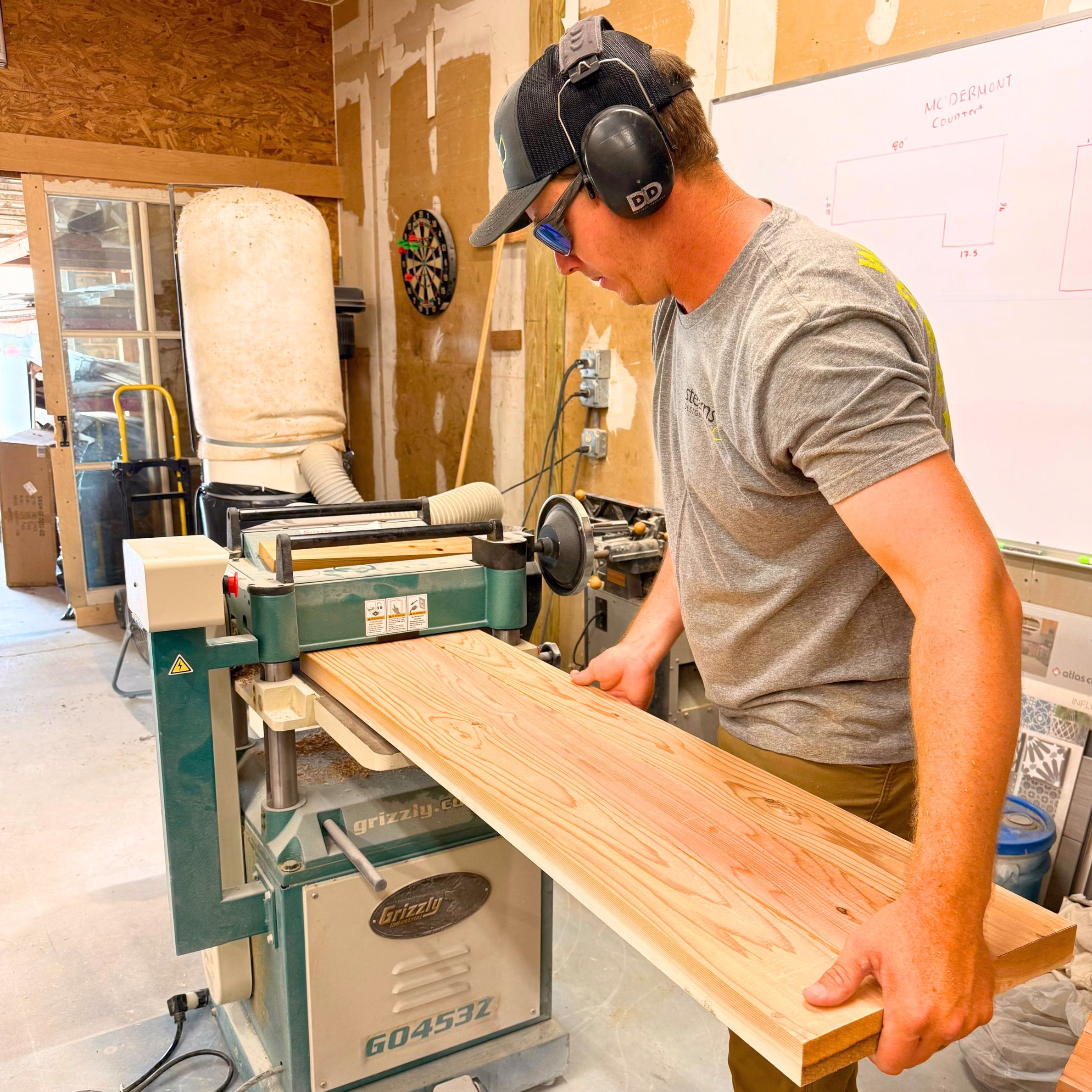Stearns Design Build craftsman preparing cedar lumber for custom benches built for Aggieland Humane Society in Bryan-College Station.