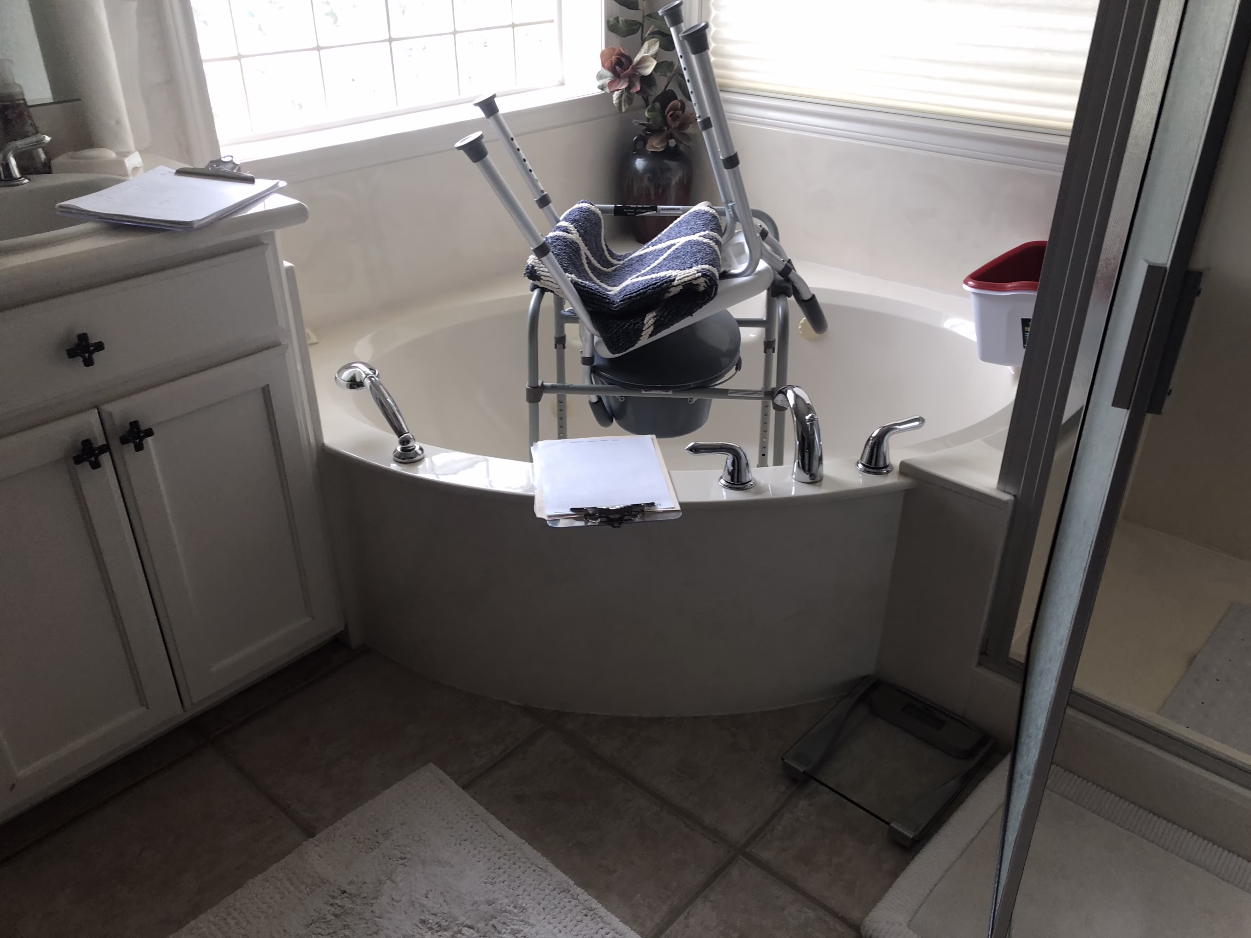 Before photo of a bathroom remodel for seniors featuring a large soaking tub with a transfer chair, illustrating accessibility challenges addressed through aging in place remodeling.