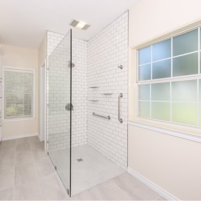Curbless walk-in shower with grab bars and barrier-free entry designed for long-term accessibility and aging-in-place.