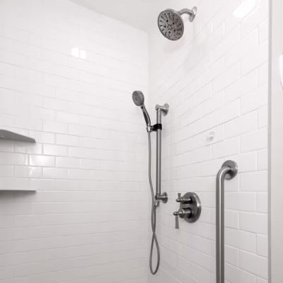 Walk-in shower with a handheld shower head on an adjustable slide bar for improved accessibility and everyday convenience.