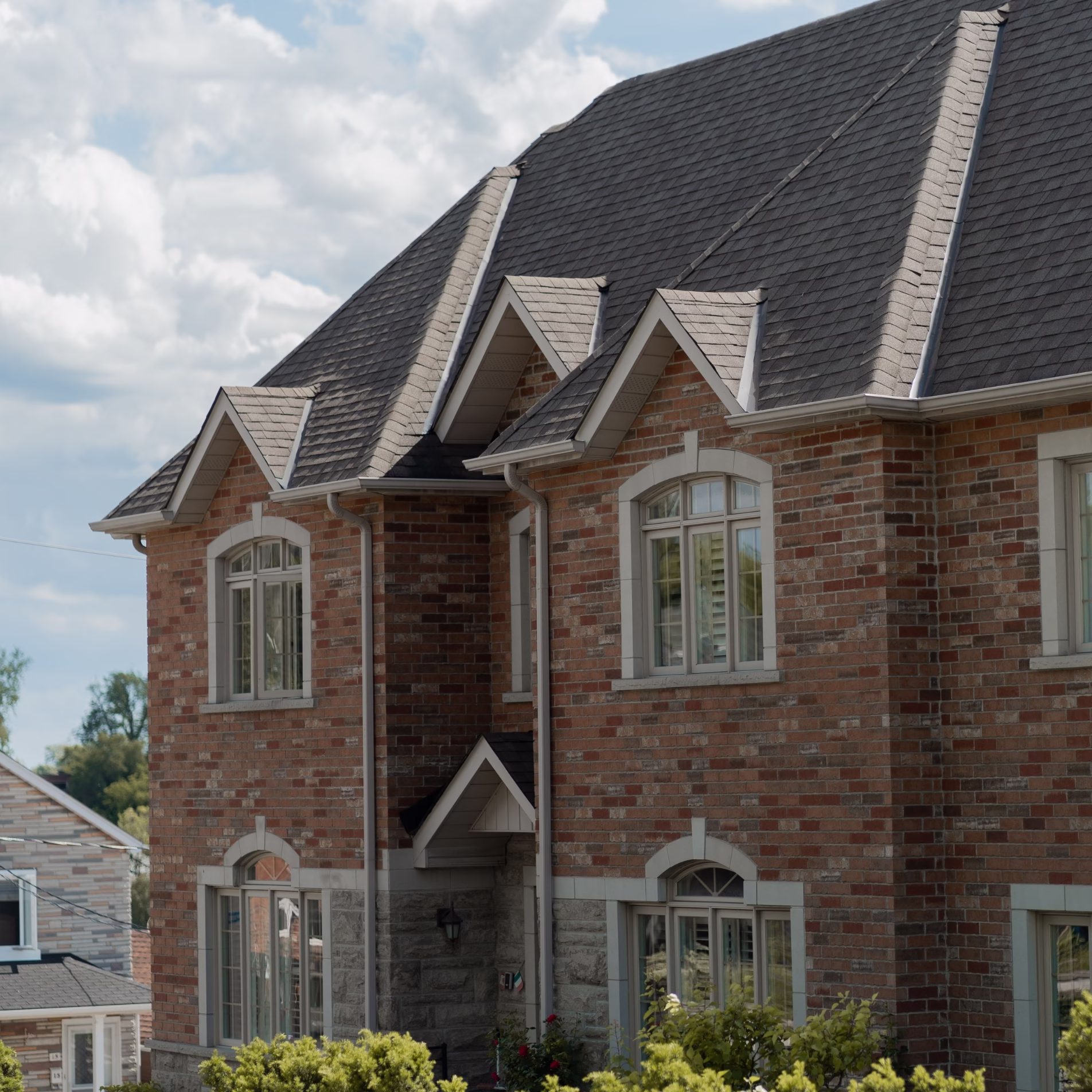 Two-story brick home showing extensive exterior masonry exposed to outdoor temperatures and sunlight.
