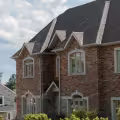 Two-story brick home showing extensive exterior masonry exposed to outdoor temperatures and sunlight.