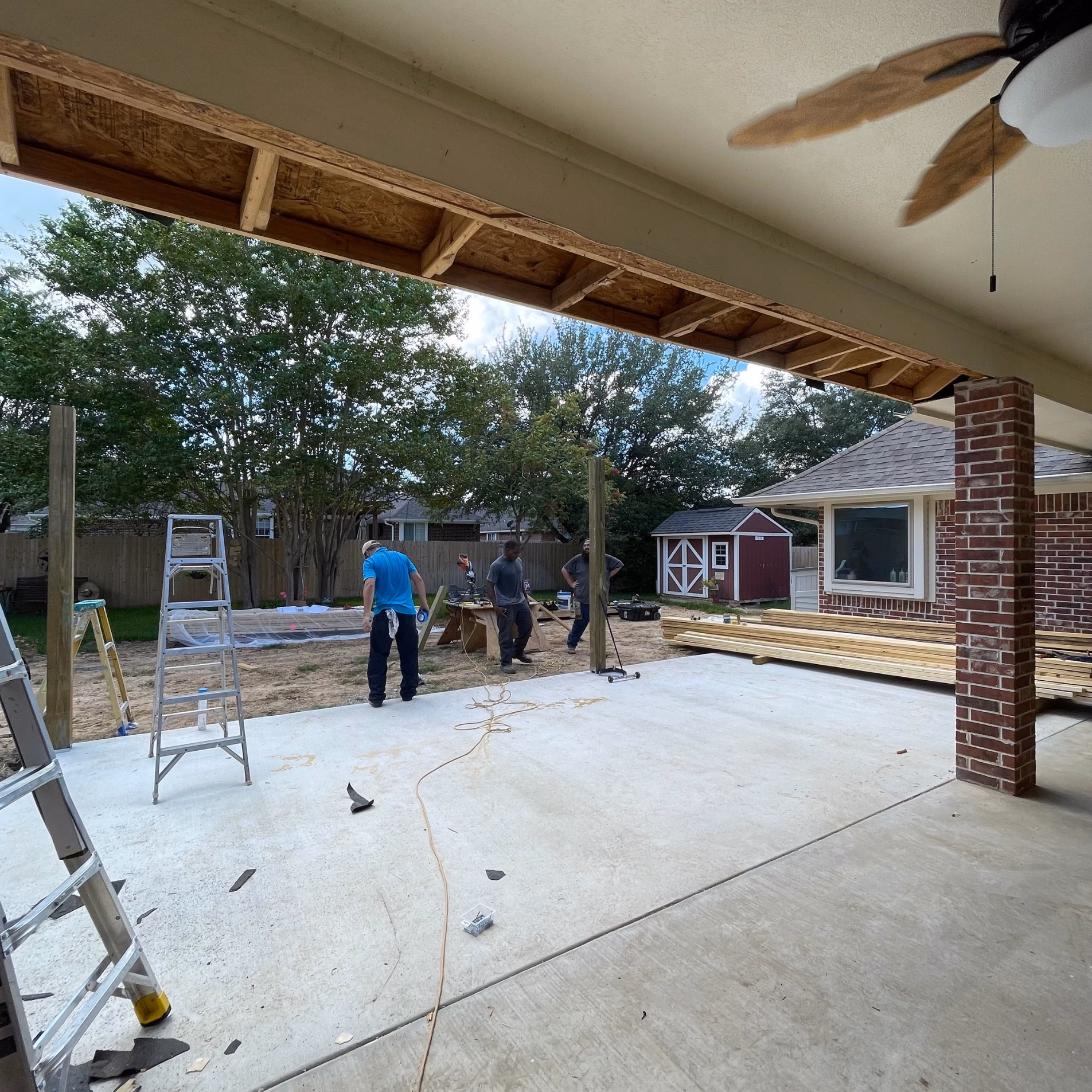 Exposed framing along the existing covered patio ceiling during construction, showing the connection area for the roof extension.